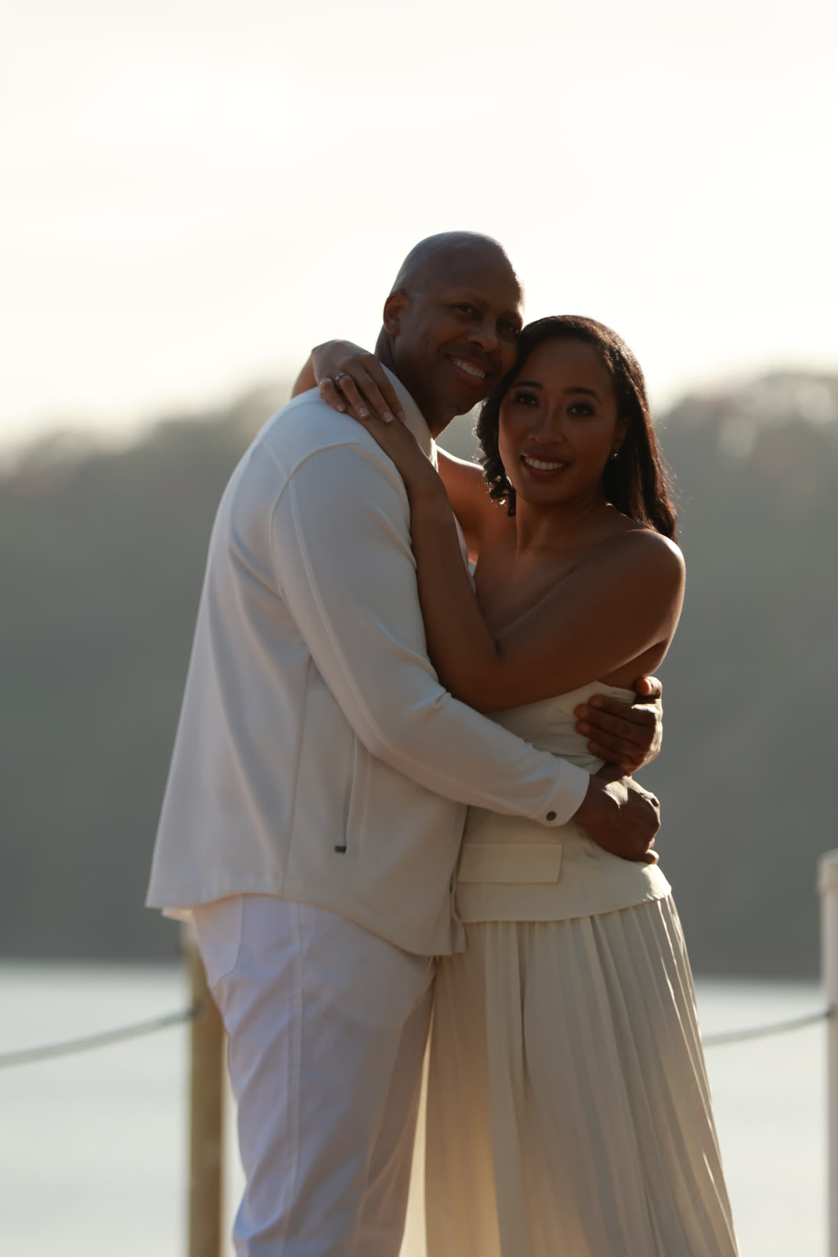 Breanna and Rob hugging at sunset by the water